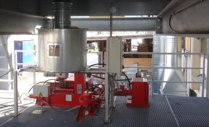 Briquetting press with feeding container under filter plant